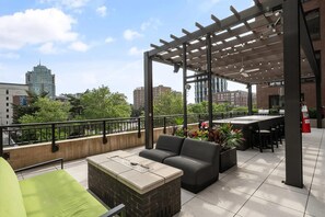 An outdoor patio with a pergola, seating, and a fire feature. - Landing | Beautiful 2BD in Central West End (St. Louis)