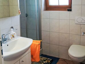 Een badkamer met een wastafel, toilet en douche.