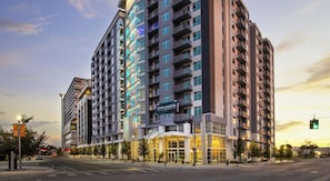 A multi-story hotel with a prominent 'Now Leasing' sign, indicating available units. - Landing | Stylish Studio, Gym, Courtyard (Orlando)