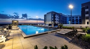 A rooftop pool with lounge chairs and a view of the sunset. - Landing | Amazing Studio, Gym, Courtyard (Orlando)