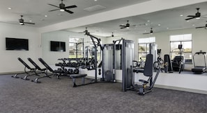 A gym with various exercise equipment, including dumbbells, benches, and cardio machines. - Landing | Chic 2BD in Downtown Dripping Springs (Dripping Springs)