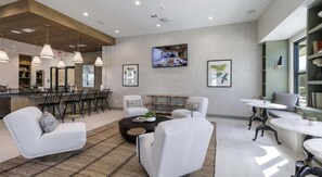 A modern living room with a dining area, a kitchen in the background, and a large window providing natural light. - Landing | Chic 2BD in Downtown Dripping Springs (Dripping Springs)