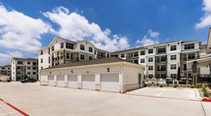 A multi-story residential building with a garage and a swimming pool. - Landing | Stylish 2BD in Downtown Dripping Springs (Dripping Springs)
