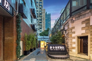 A narrow alleyway leading to a hotel entrance with a signboard. - Jing'an TRUE GO Hotel  (Shanghai)