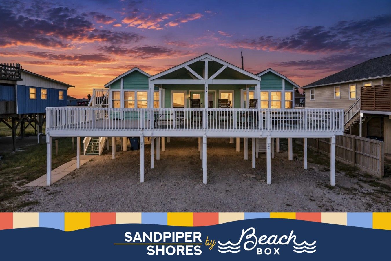 A beachfront property with multiple houses, a covered deck, and a sandy ground.