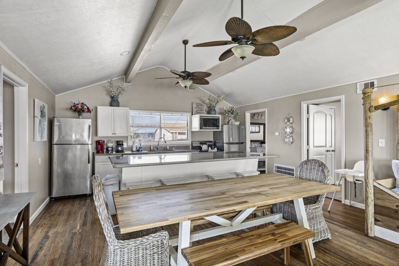 A modern kitchen with a central island, stainless steel appliances, and a ceiling fan.