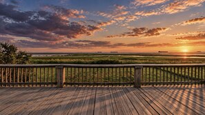 A wooden deck with a view of a sunset over a marshy landscape. - Warblers Roost- Bird Watcher Paradise | Great view (Crystal Beach)