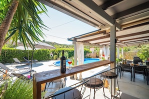 An outdoor patio with a pool, bar area, and seating. - Villa Casa del Miele - Holidays in Crete (Skonízo)