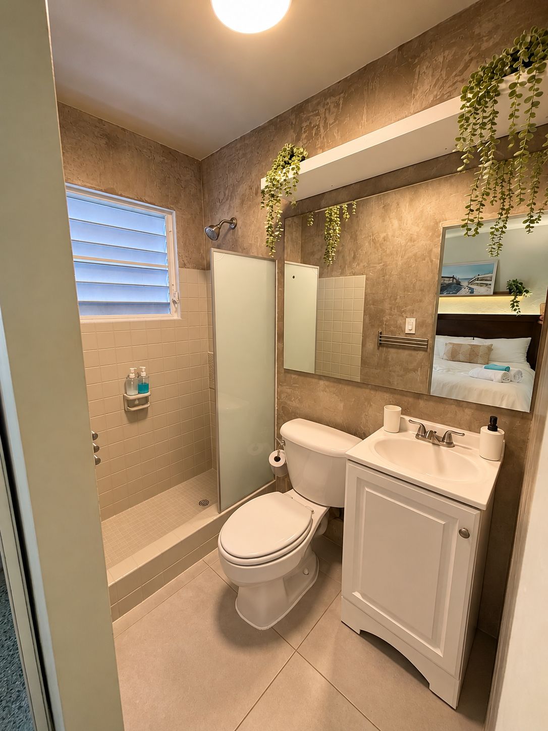 A bathroom with a toilet, sink, and shower.