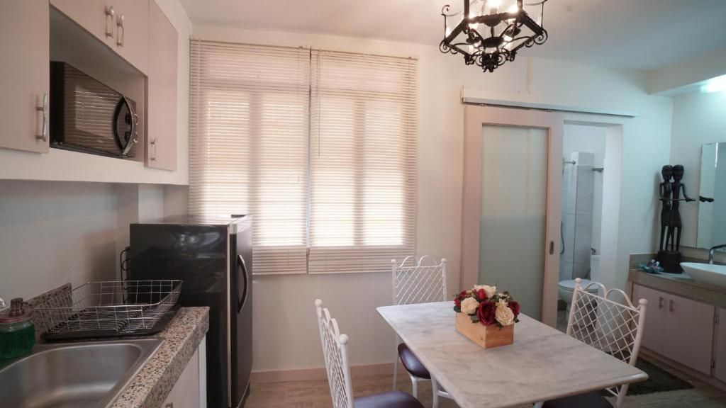 Una cocina compacta con mesa, sillas y refrigerador.