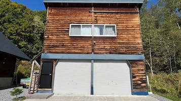 Un bâtiment à deux étages doté d’une porte de garage et d’un petit porche.