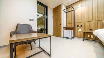 Una habitación de hotel moderna con un panel de madera en la pared, una cama, un escritorio y una silla.