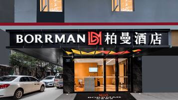 Een hotelingang met een modern ontwerp, met een opvallend bord waarop de naam 'BORRMAN' en Chinese karakters staan.