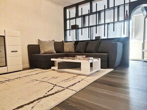 Una sala de estar moderna con un sofá modular, una mesa de centro y una alfombra estampada.