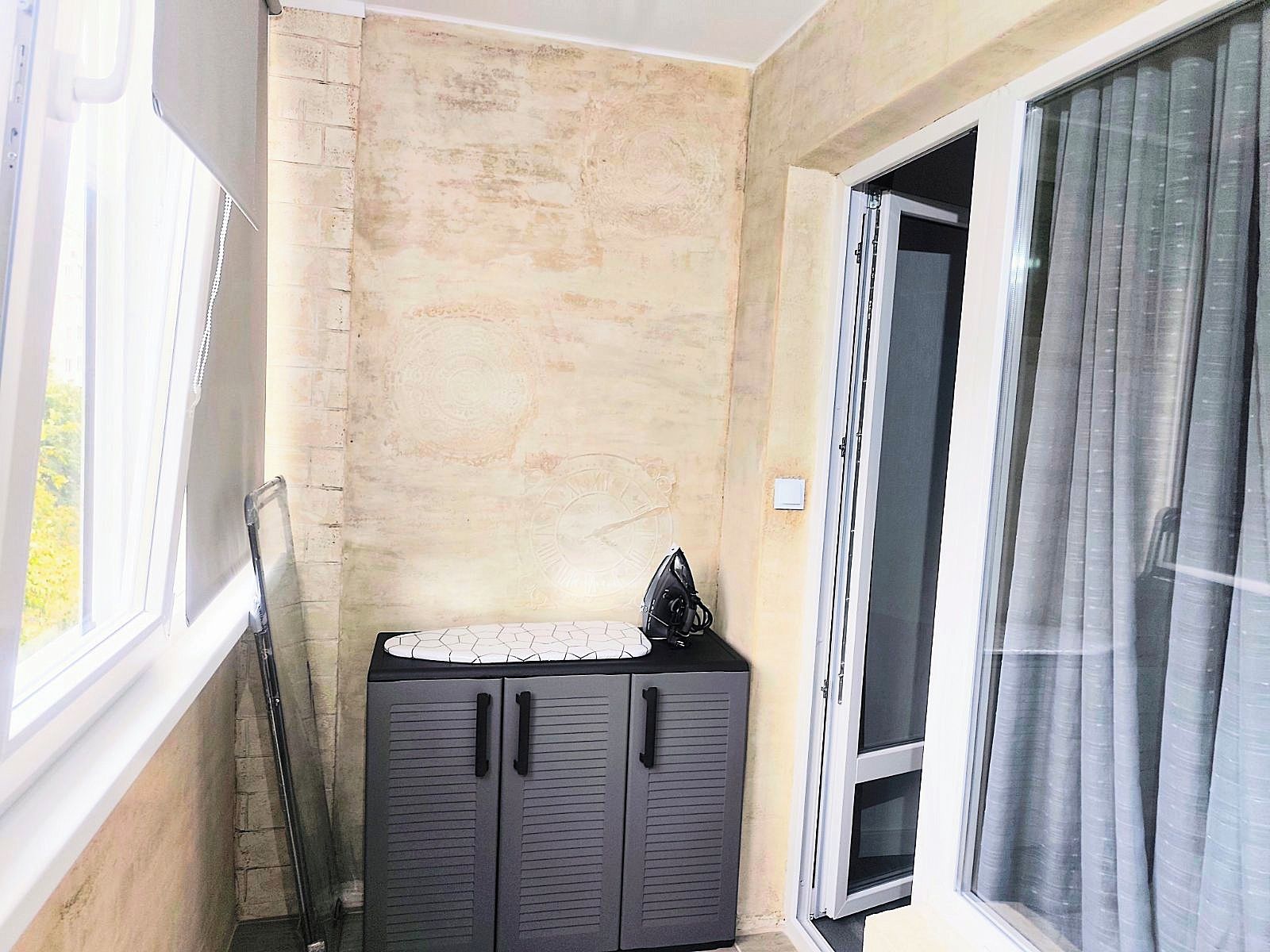 A corner room with a window, a door, and a cabinet.