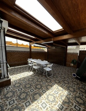 An attic room with a high ceiling, skylight, tiled floor, and a table with chairs. - New Listing (Barbate)