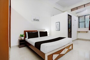 Een hotelkamer met een bed, nachtkastje en een potplant.