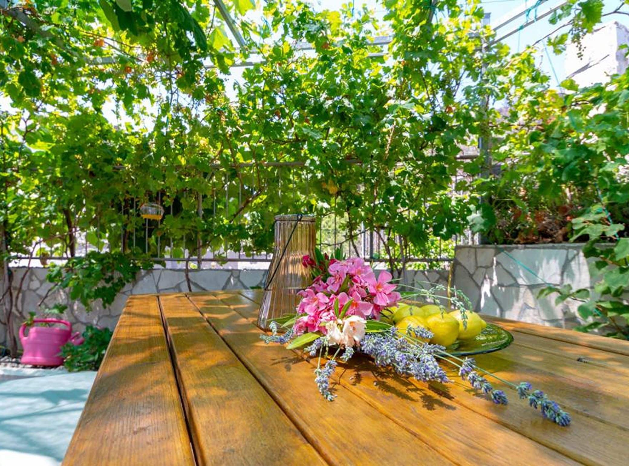 A wooden table with a floral arrangement and lemons.