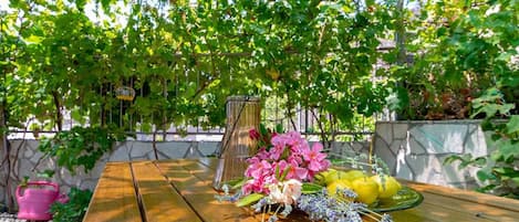 A wooden table with a floral arrangement and lemons.
