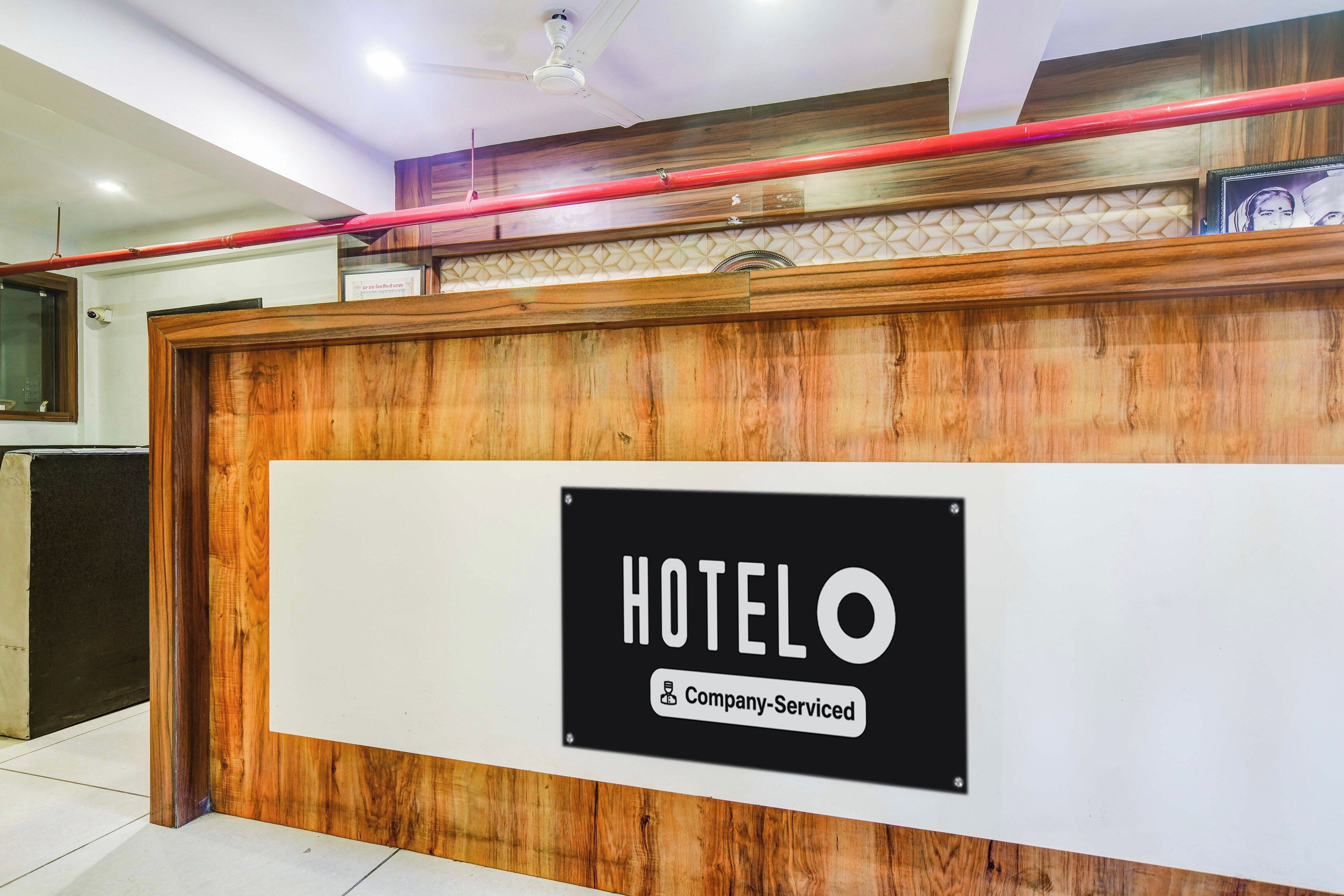 Un mostrador de recepción con un cartel que dice 'HOTEL' y 'Servicio de Empresa'.