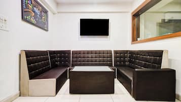 Uma sala de estar moderna com sofá seccional, televisão de tela plana e janela.