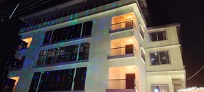 A multi-story building with balconies and windows, adorned with string lights. - DREAMLAND PALACE (Siliguri)