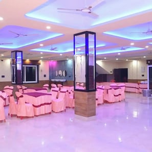 A spacious hall with rows of chairs, ceiling fans, and a central pillar. - DREAMLAND PALACE (Siliguri)