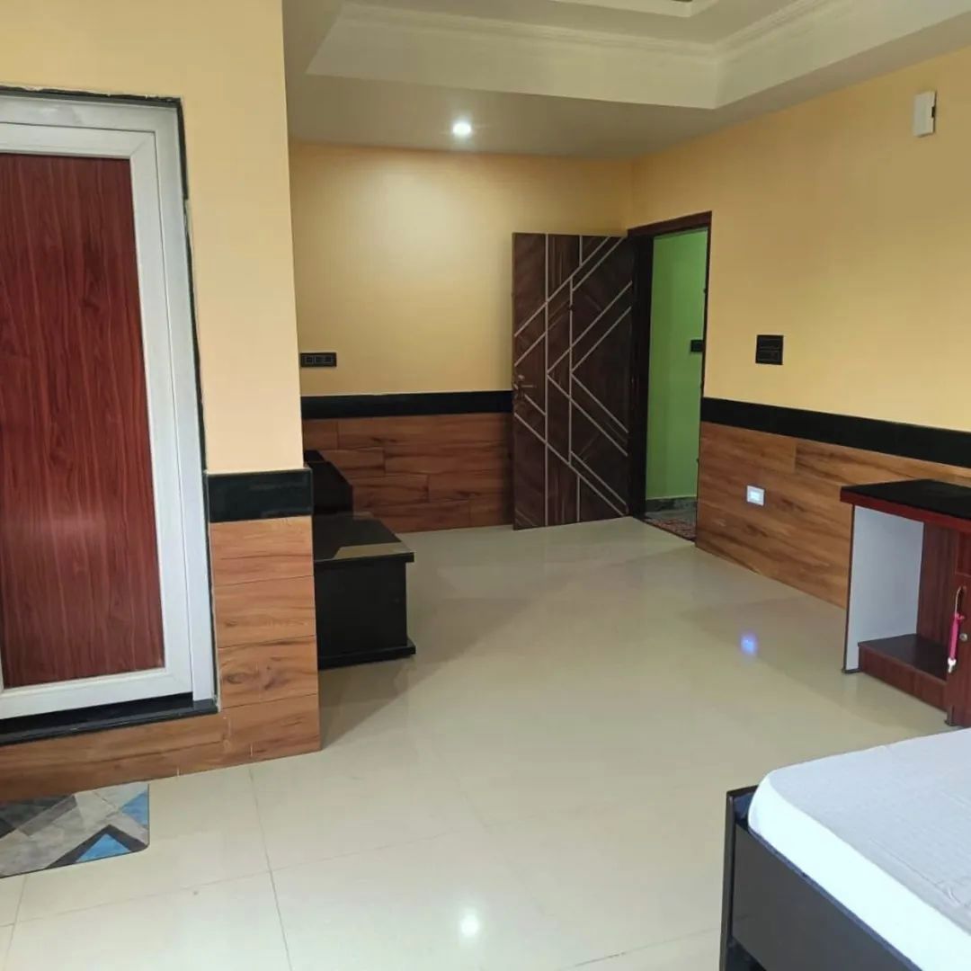 Habitación de hotel con cama, escritorio, armario y puerta.