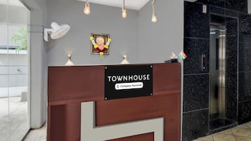 A reception desk with a sign indicating it is a company-serviced townhouse.