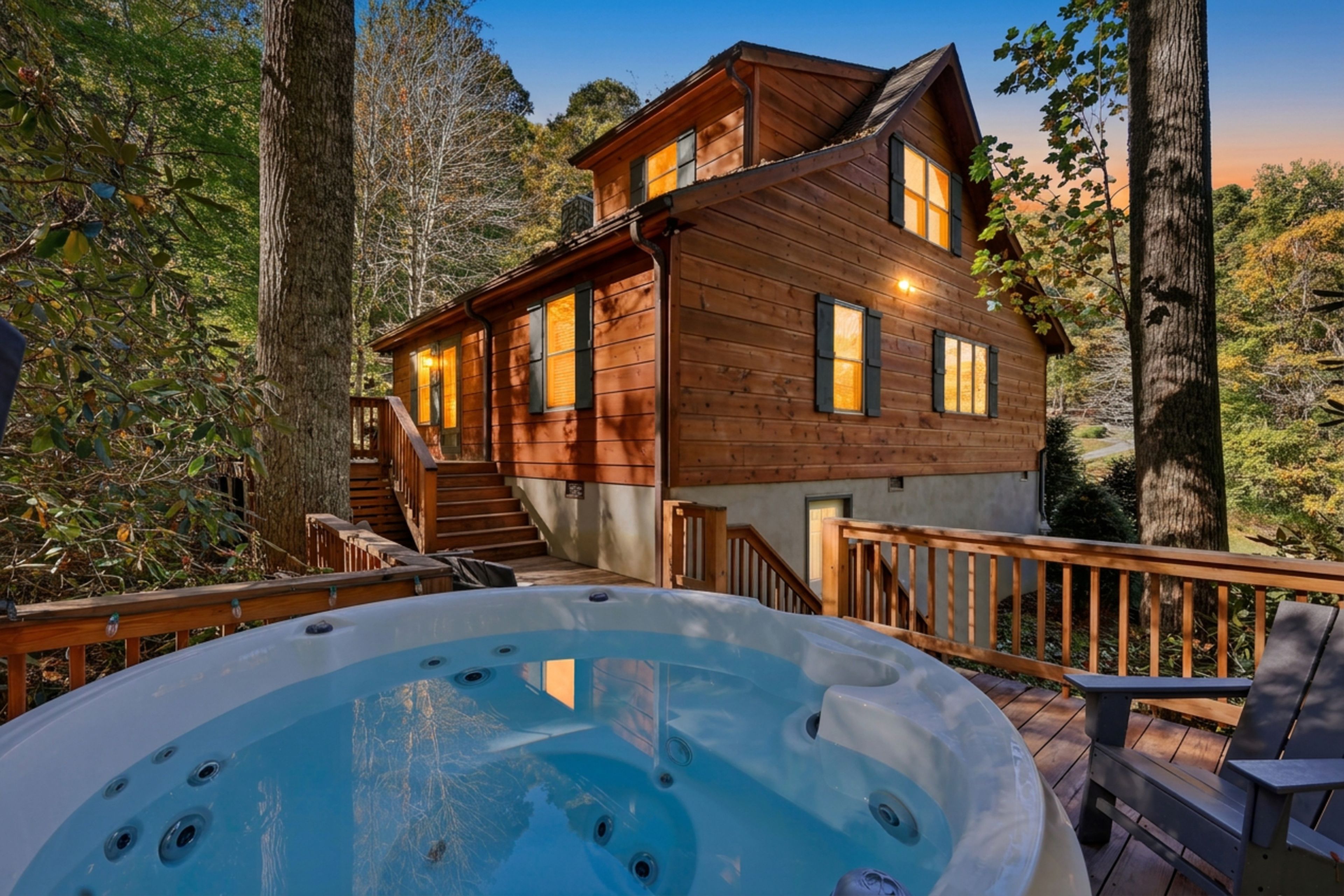 A wooden cabin with a hot tub on a deck, surrounded by trees.
