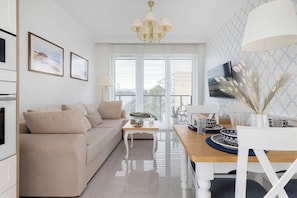 A modern living room with a sofa, coffee table, and dining area. - Gdansk | Kaczyńskiego 18F | Bright Apartment | Balcony (Gdańsk)