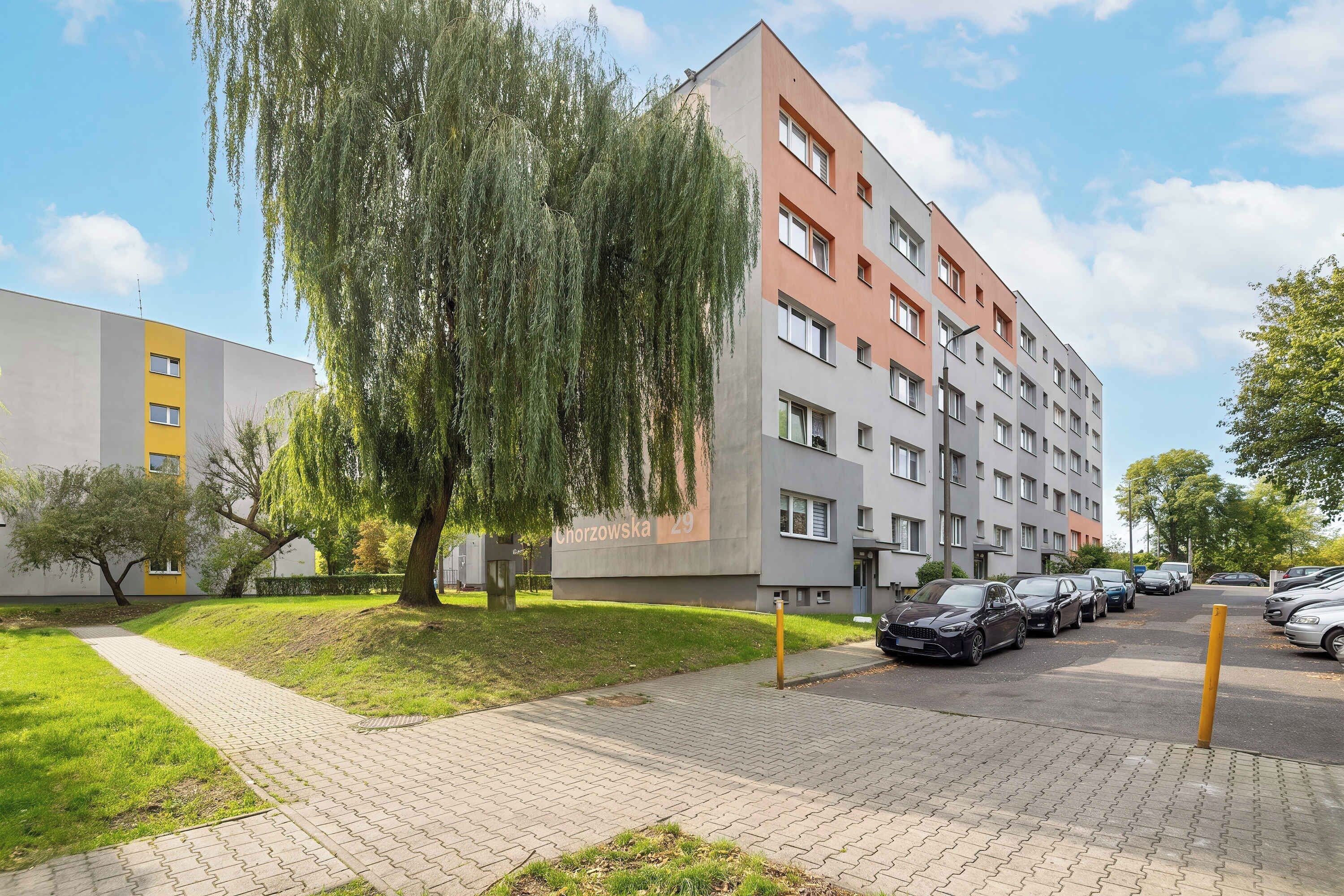 Un immeuble résidentiel à plusieurs étages avec un espace de stationnement à l’avant.