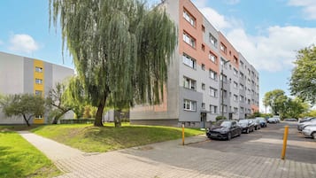 Un immeuble résidentiel à plusieurs étages avec un espace de stationnement à l’avant.