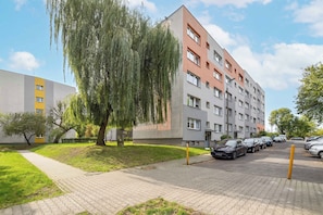 Un immeuble résidentiel à plusieurs étages avec un espace de stationnement à l’avant.