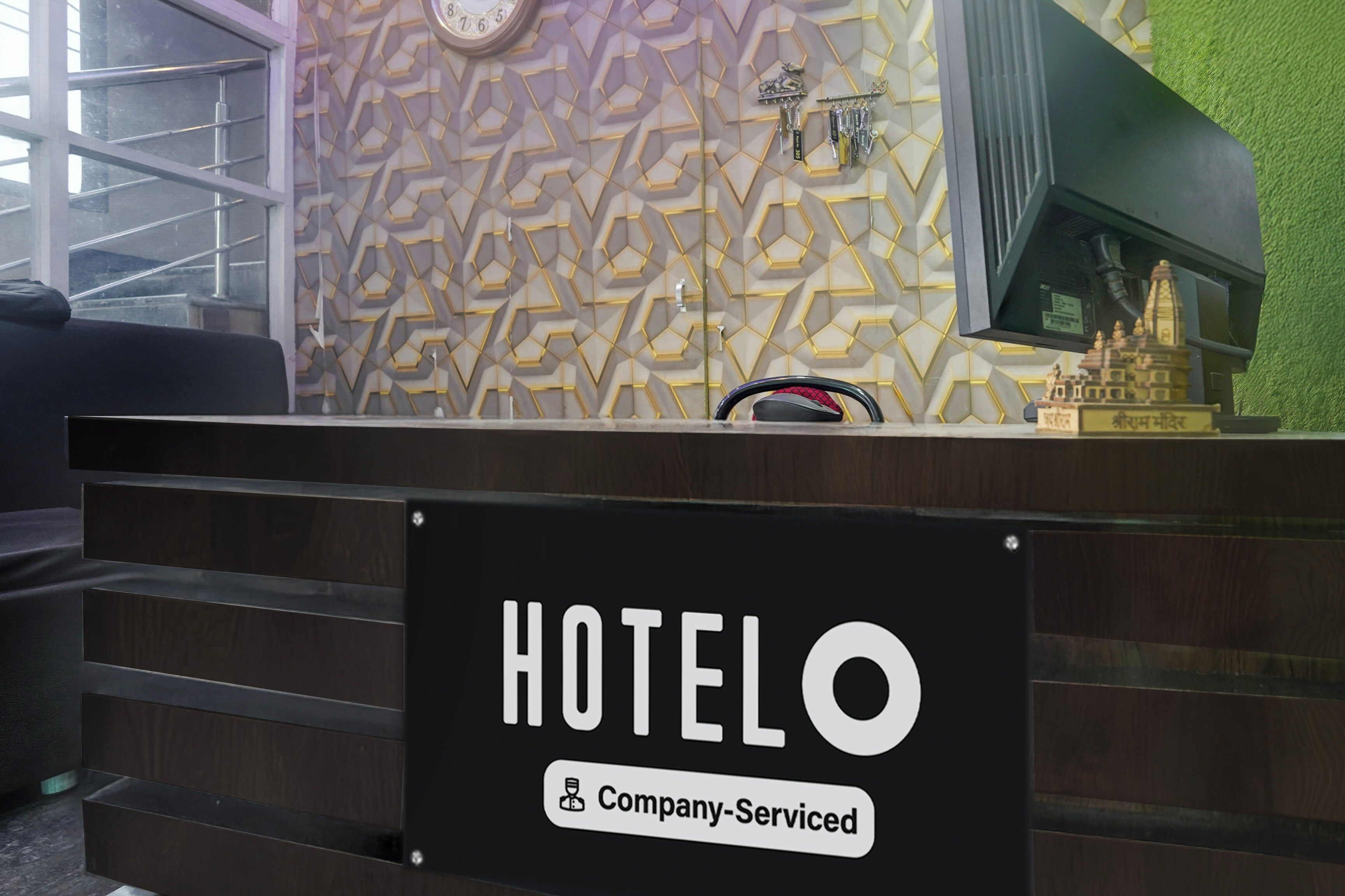 Mostrador de recepción de hotel con un letrero que indica servicio de empresa.