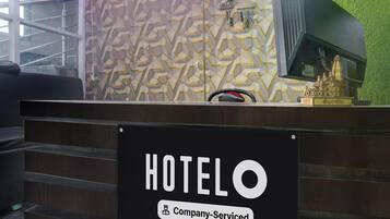 Mostrador de recepción de hotel con un letrero que indica servicio de empresa.