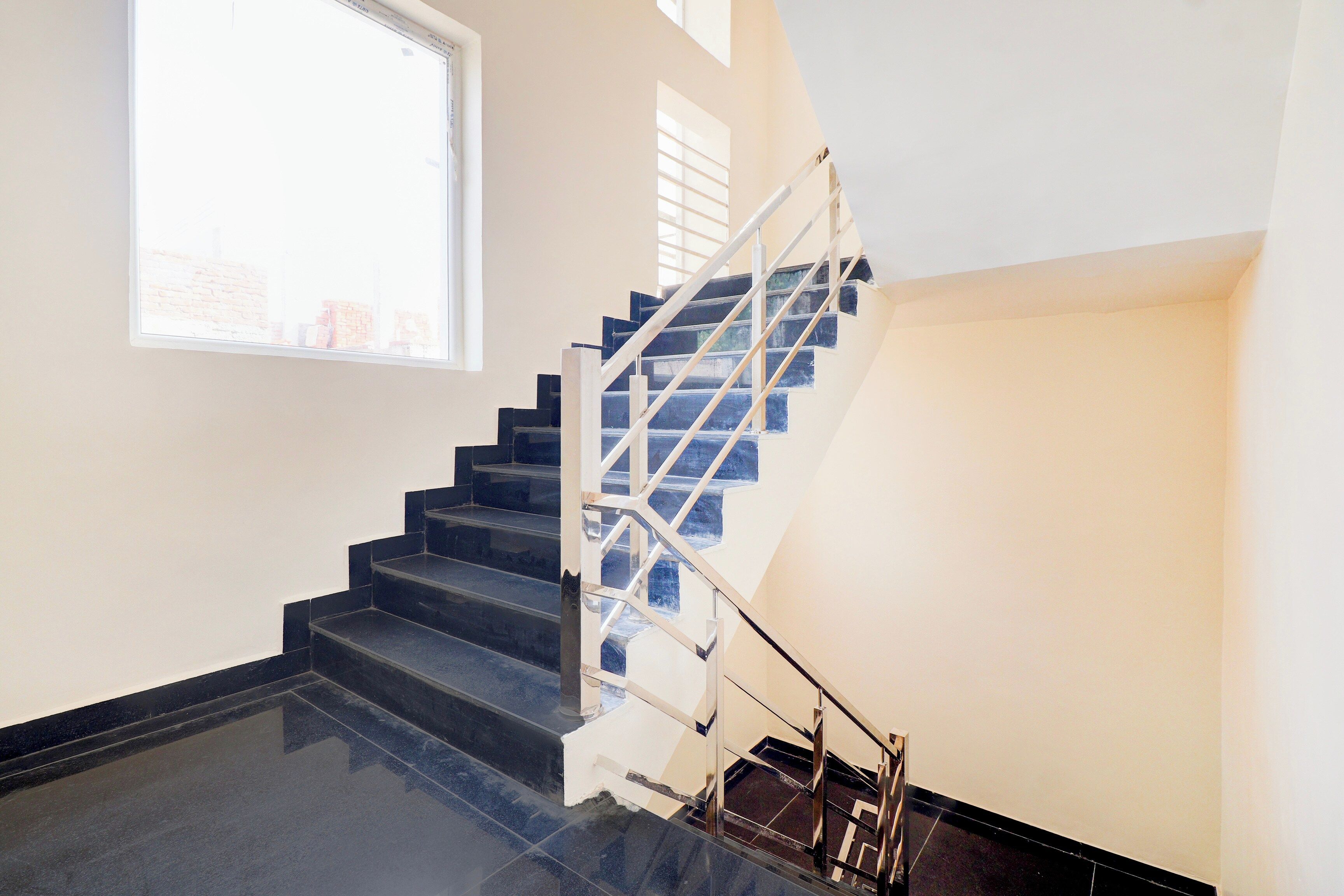 A staircase with a metal railing, leading to an upper floor.