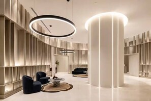A modern interior with a central column, recessed lighting, and a seating area with a round table. - Luxe 1BR | Queen’s Wharf | Casino & Pool (Brisbane City)