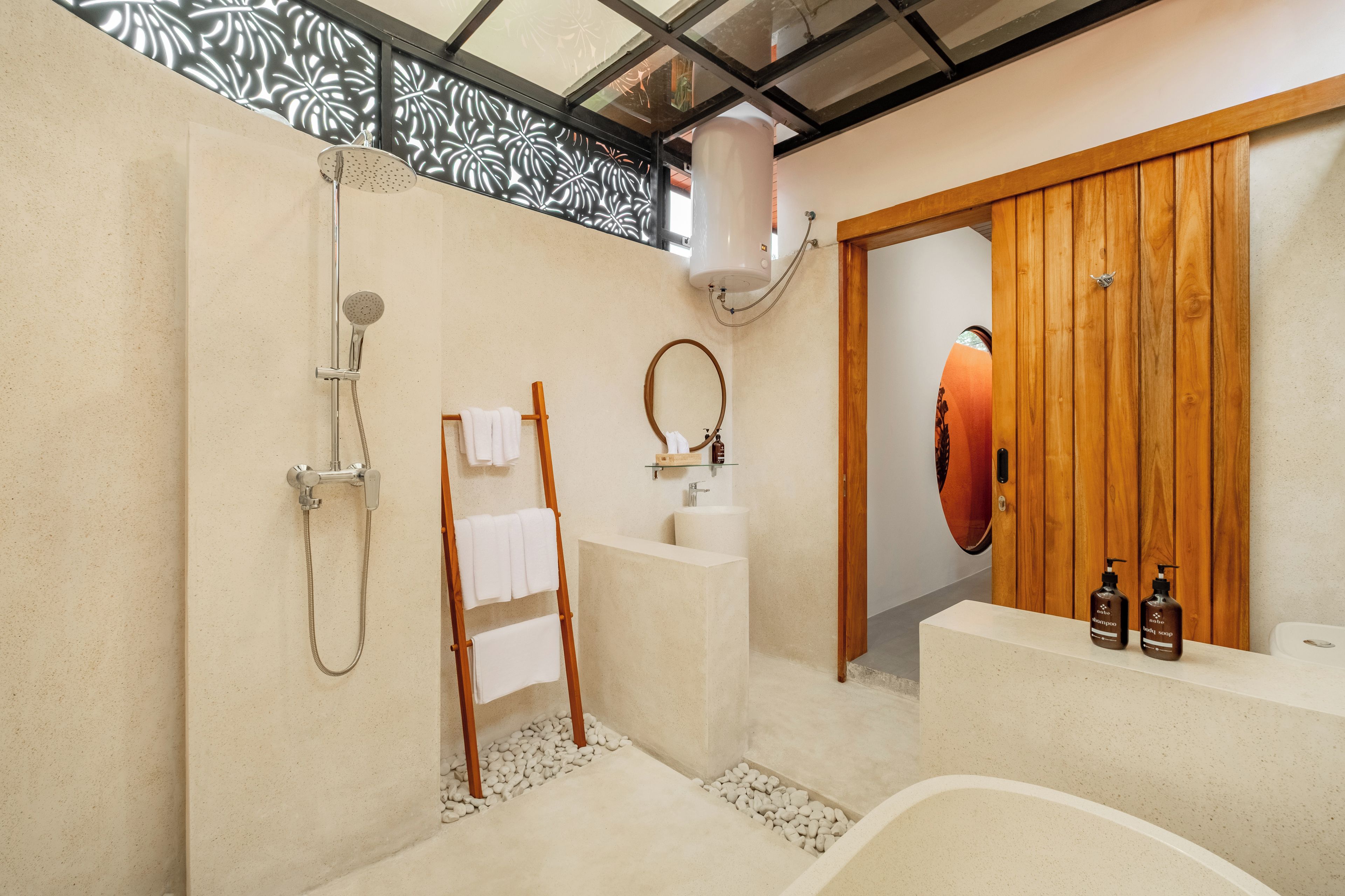 A modern bathroom with a shower, a bathtub, a wooden door, and a vanity with toiletries.
