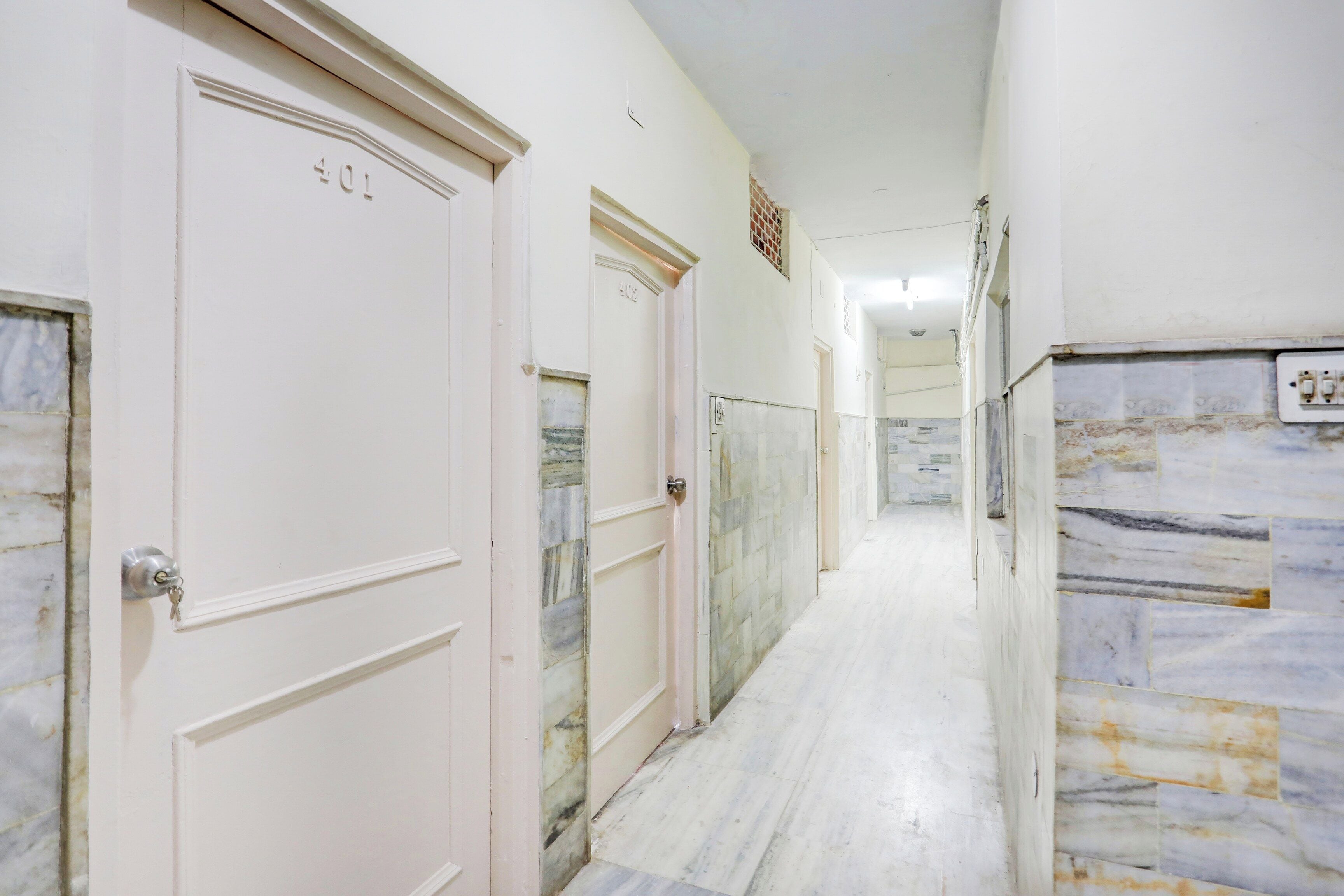 Un pasillo con puertas numeradas 401 y 402, que da acceso a habitaciones.