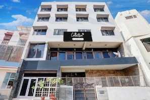 Un edificio de varios pisos con un cartel que indica que cuenta con servicios de empresa.