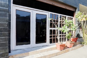 A building entrance with a set of double glass doors and a small step leading up to the entrance.