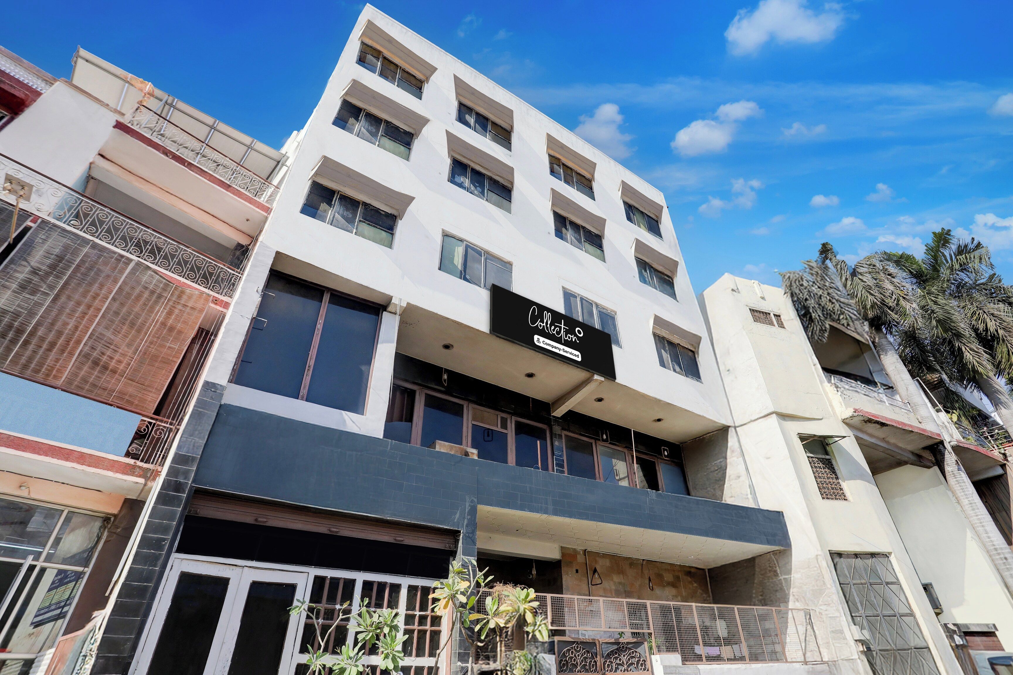 Un edificio de varios pisos con un letrero que indica que es un complejo de apartamentos y ofrece servicios para empresas.
