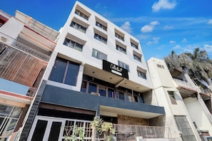 A multi-story building with a sign indicating it is a collection and company-serviced property.