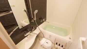 A bathroom with a bathtub, a sink, a toilet, and a mirror.