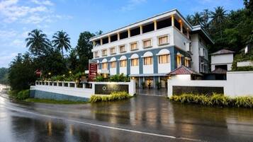 Un hotel de varios pisos con una fachada moderna, una entrada bien conservada y un área de estacionamiento.