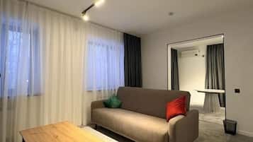 Una sala de estar moderna con un sofá, una mesa de centro y un comedor con mesa y sillas.