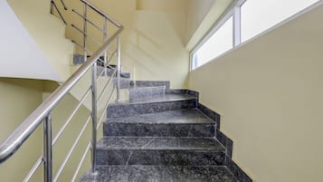 Un conjunto de escaleras de mármol con barandilla de metal que conducen a un piso superior.