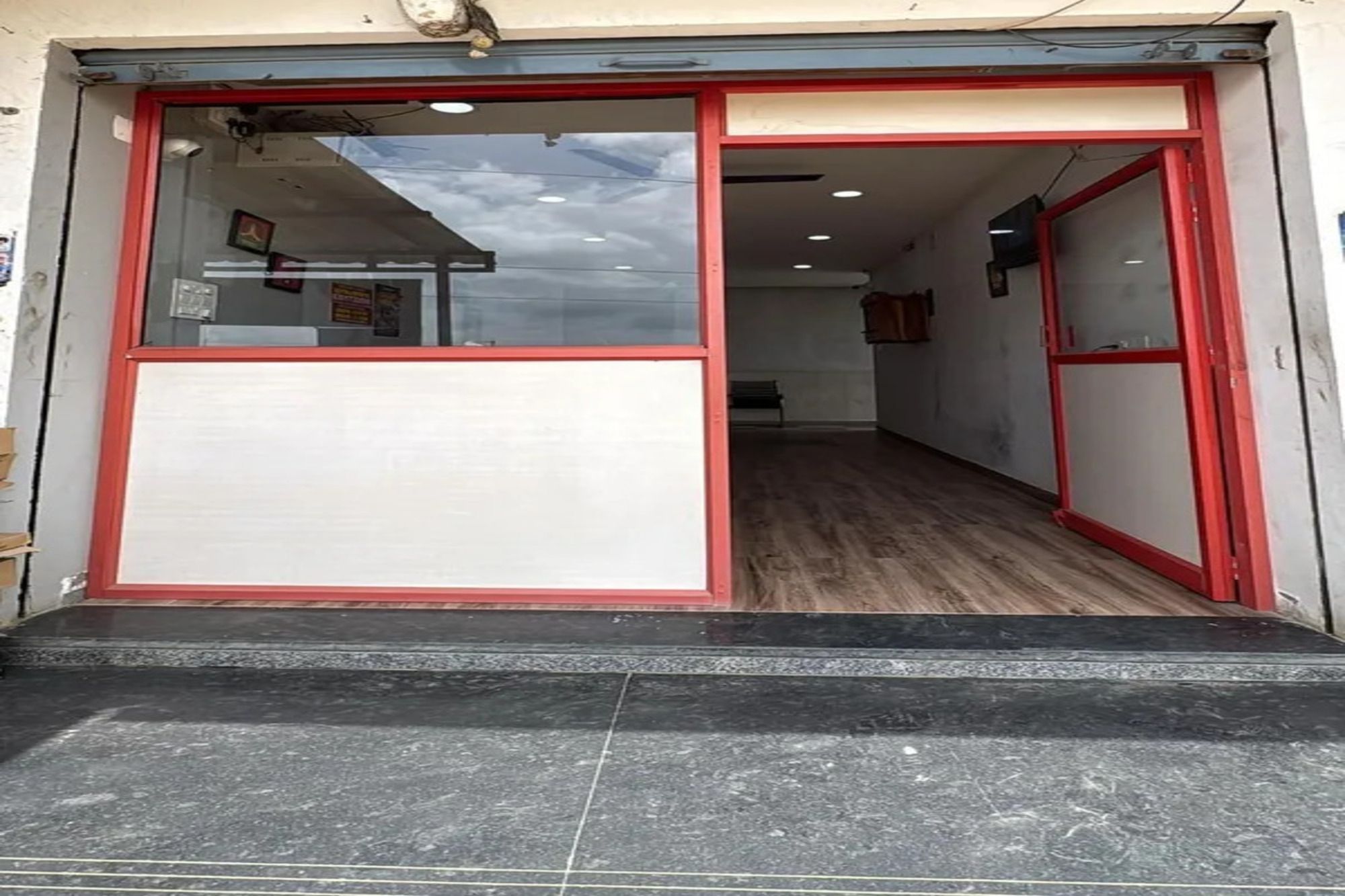 Entrada de un hotel con puerta de cristal y suelo de baldosas.