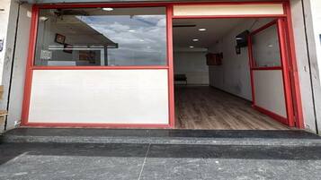 Entrada de un hotel con puerta de cristal y suelo de baldosas.